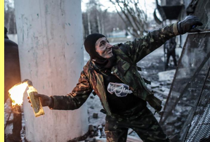 Protestatário a lançar um coquetel molotov junto ao Estádio Dynamo, de Kiev.